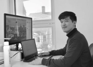 black and white image of Sunghwan Lim sitting in front of a desk with a computer