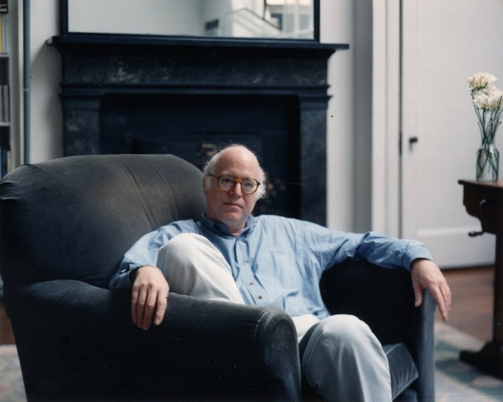 Man sits in arm chair.