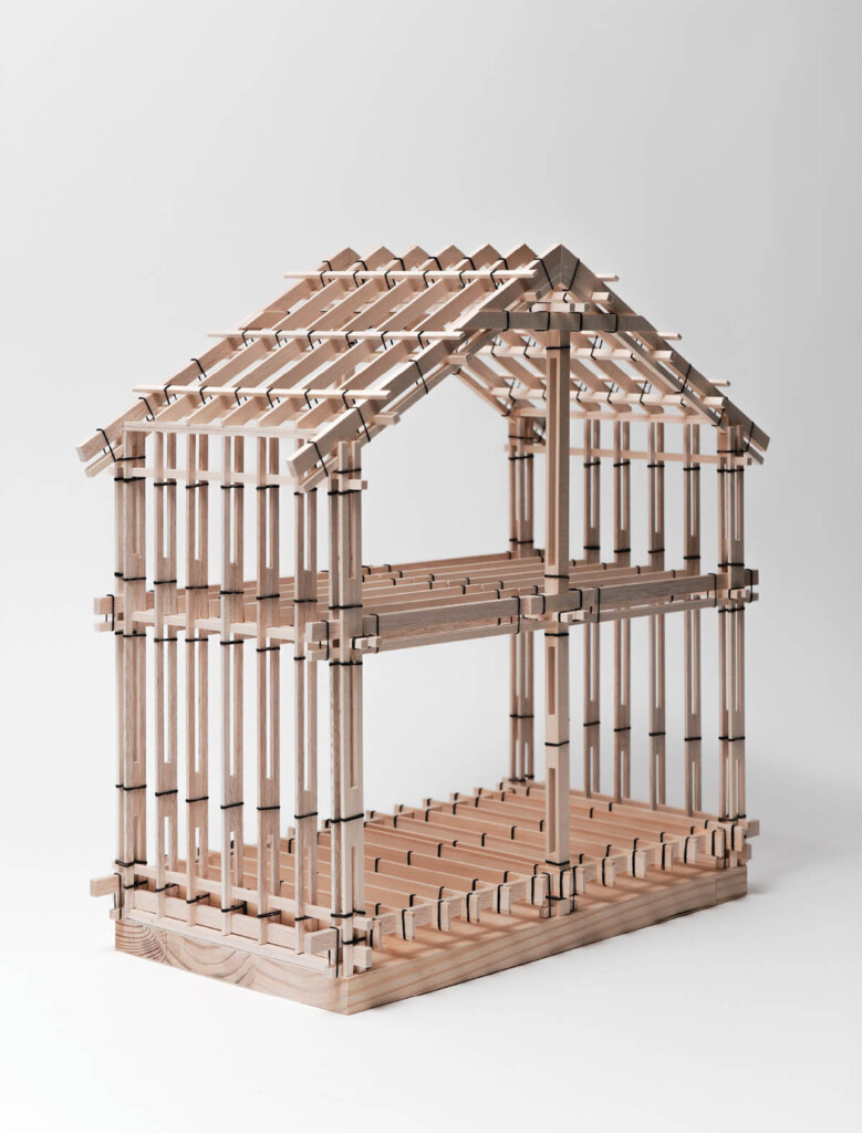 wood model of a small sectiom of a timber contruction of a house. The members are held together with rubberbands.